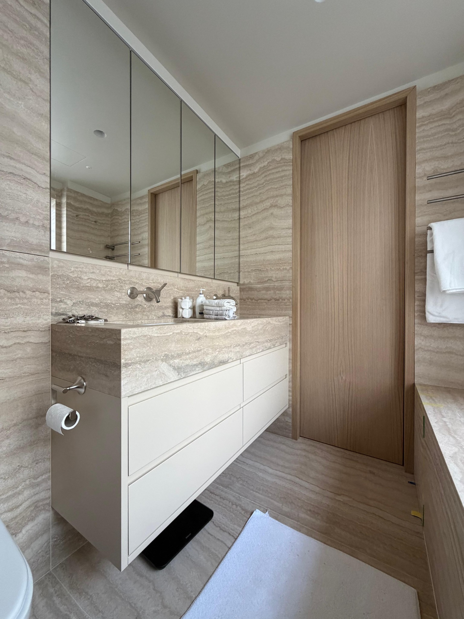 Light-coloured bathroom vanity with mirrored cabinet
