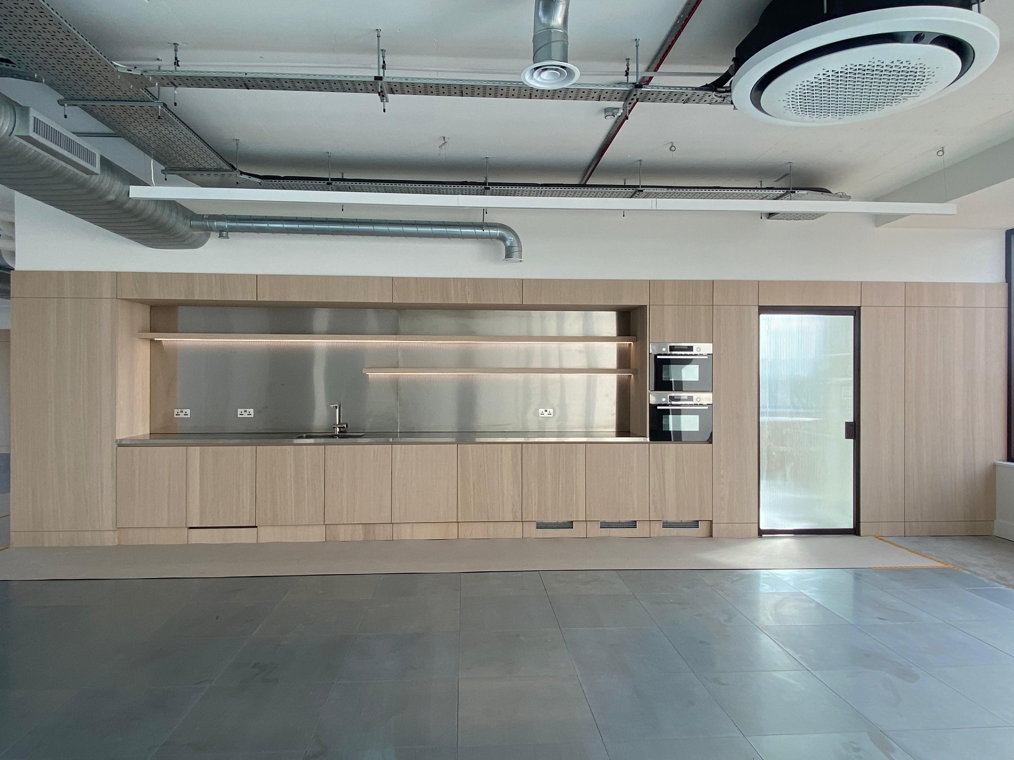 Commercial fitted kitchenette within timber panelling