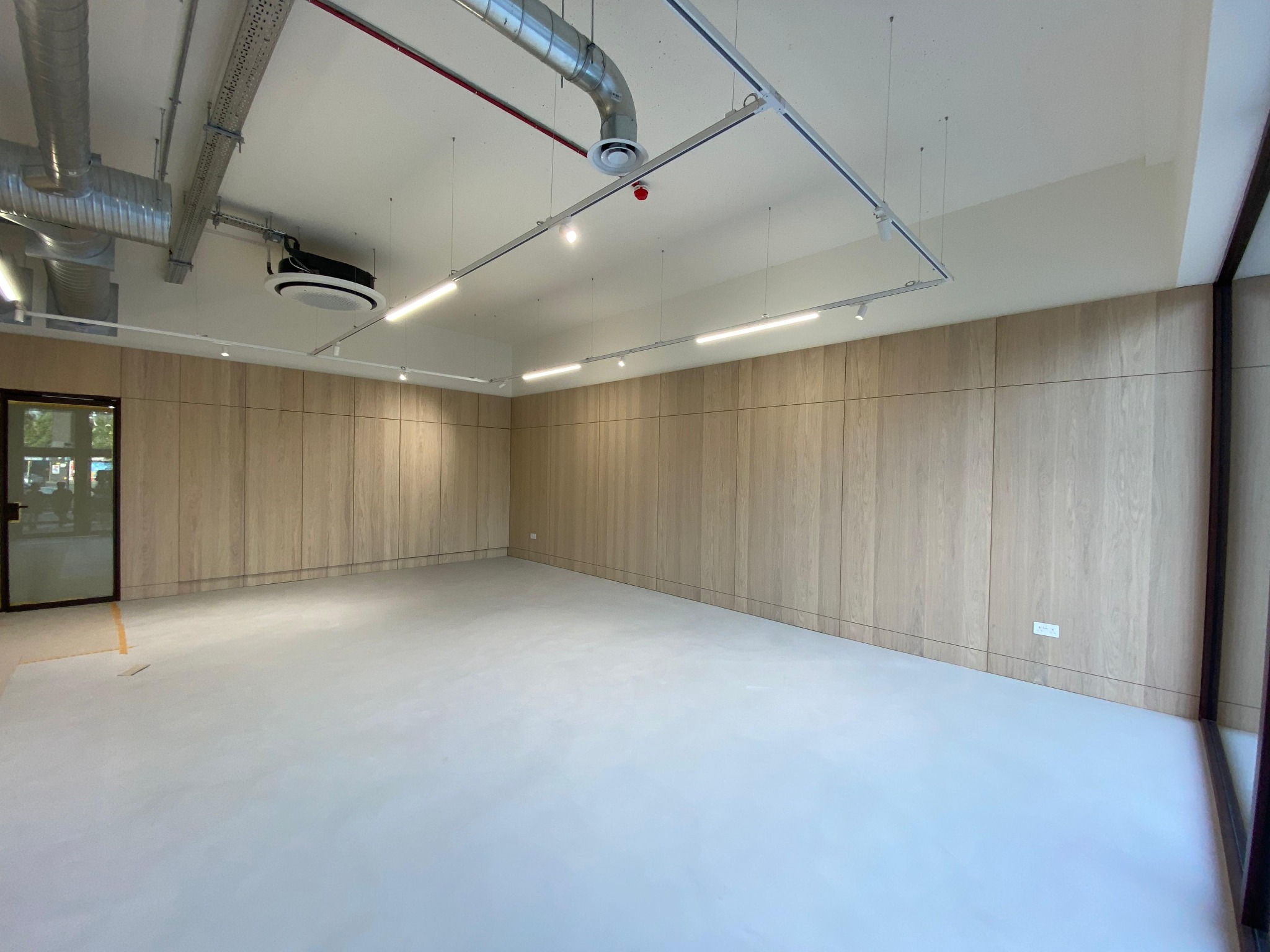 Commercial room with full-height light timber wall panels